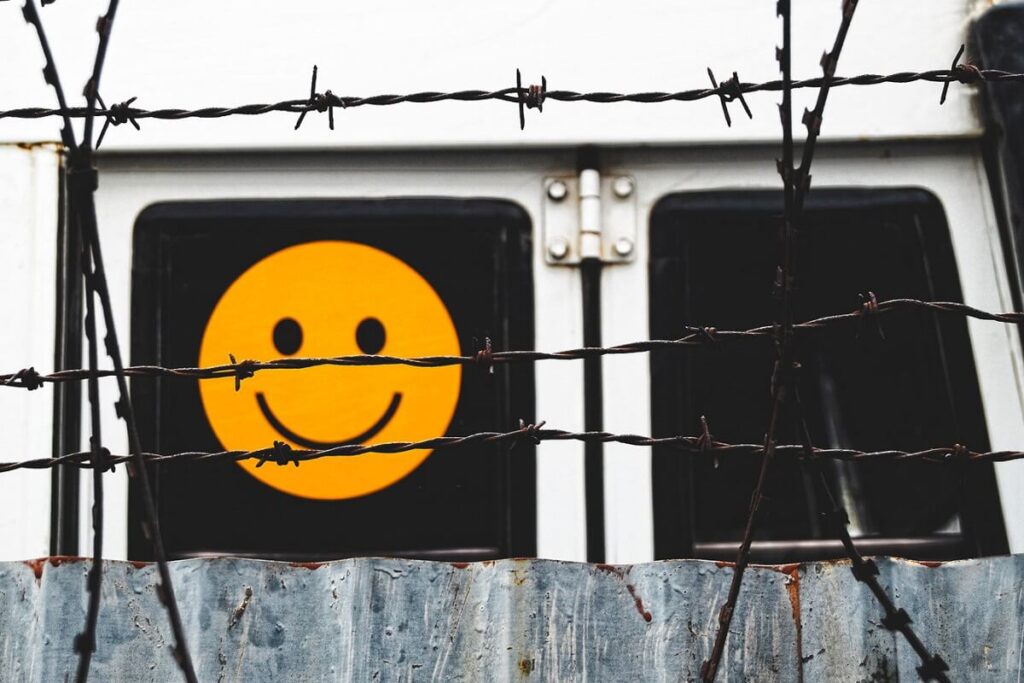 smiley face behind barbed wire