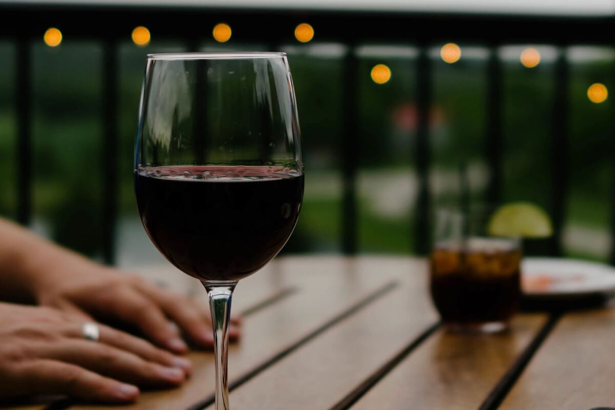 Closeup of wine glass on wooden table with hands