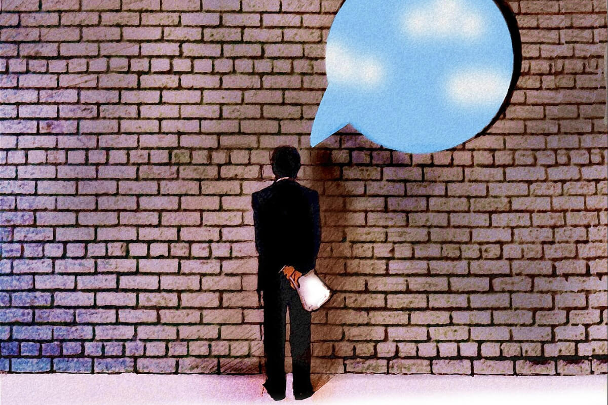 Man looking at brick wall thinking with speech bubble hole in wall