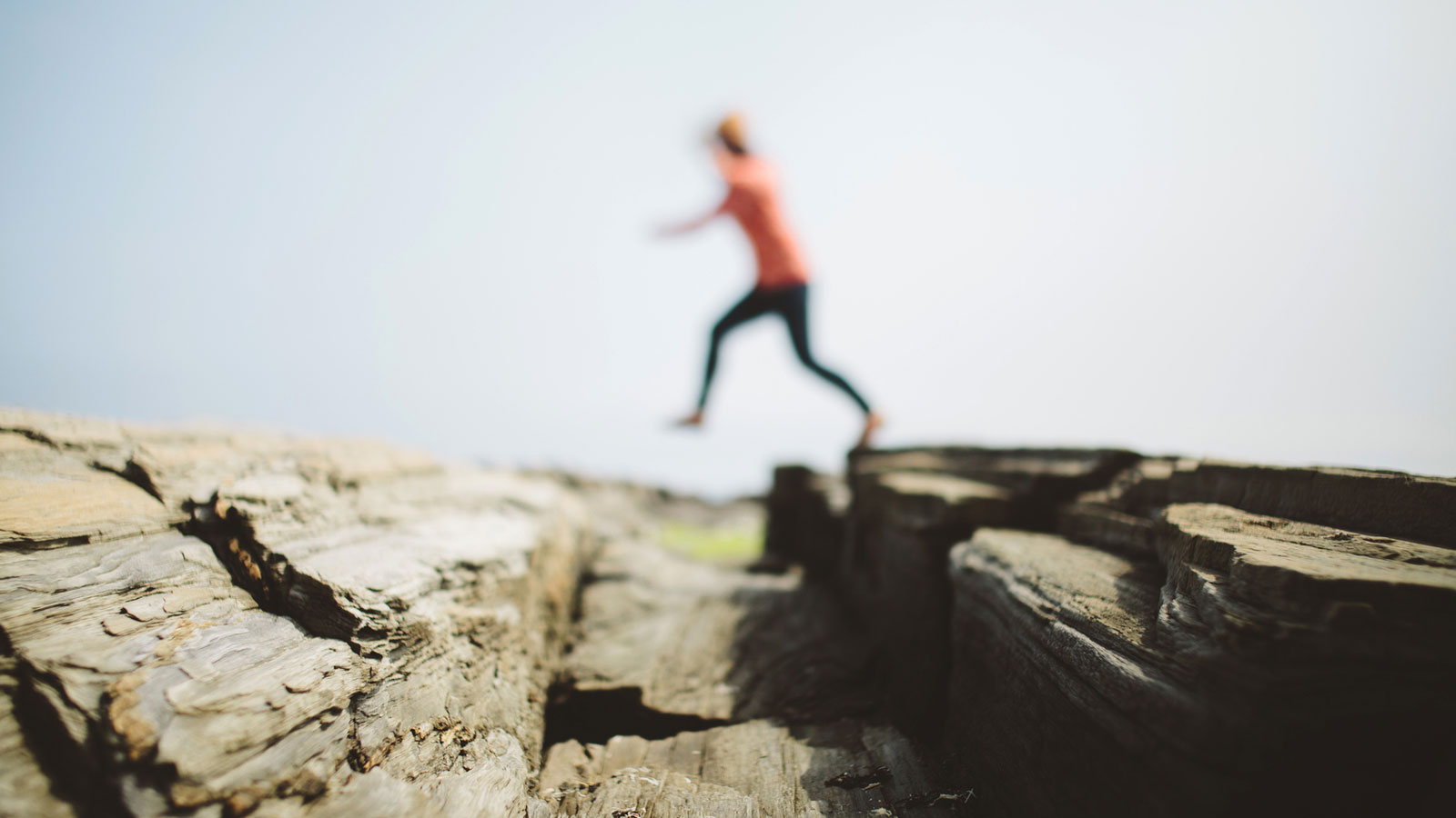 out of focus woman jumping over rocks