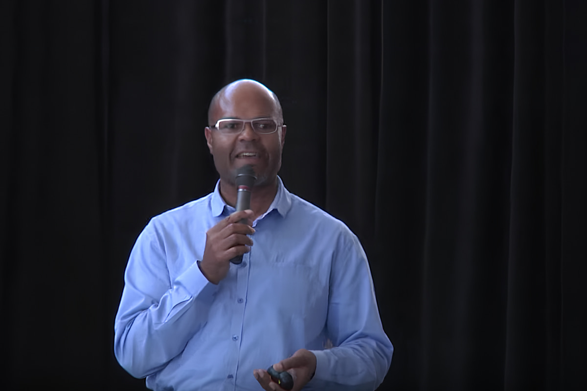 Chris Murchison giving presentation on stage with microphone