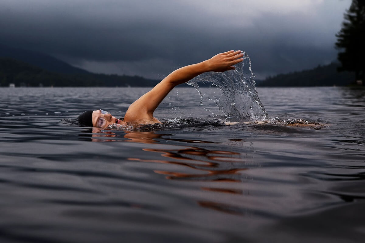 Woman with skull cap swimming in lake