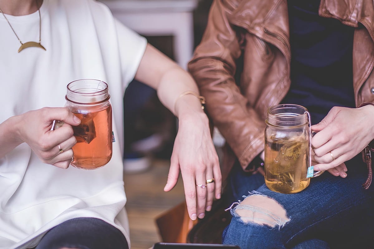 people drinking tea from a mason jars