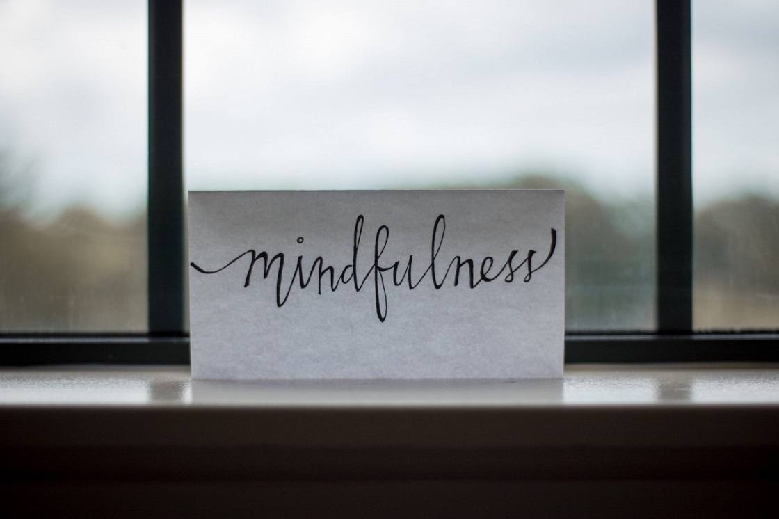Mindfulness written on paper laying against window