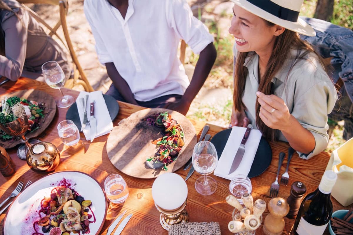People eating and smiling at outdoor table