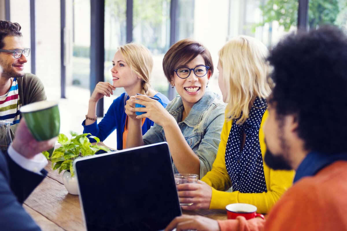 Group of employees chatting while drinking coffee