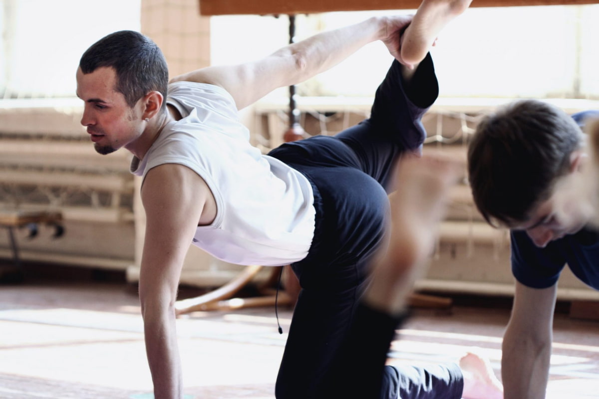 Young man in yoga class stretching calves