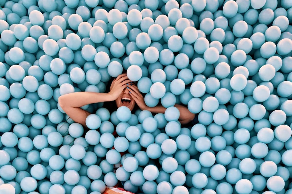 Woman laughing in blue ball pit