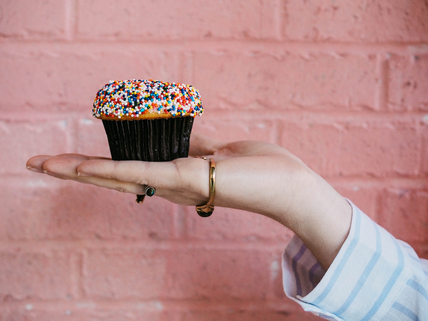 Hand holding a cupcake