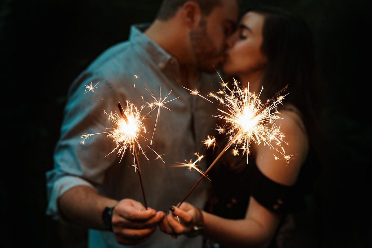 Couple kissing while holding sparklers