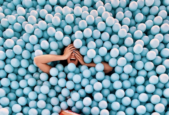 Woman laughing in blue ball pit