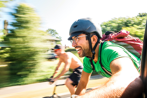 Two men riding on a bike smiling