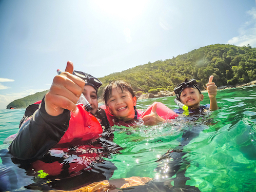 Mother and children smiling and posing while scuba diving
