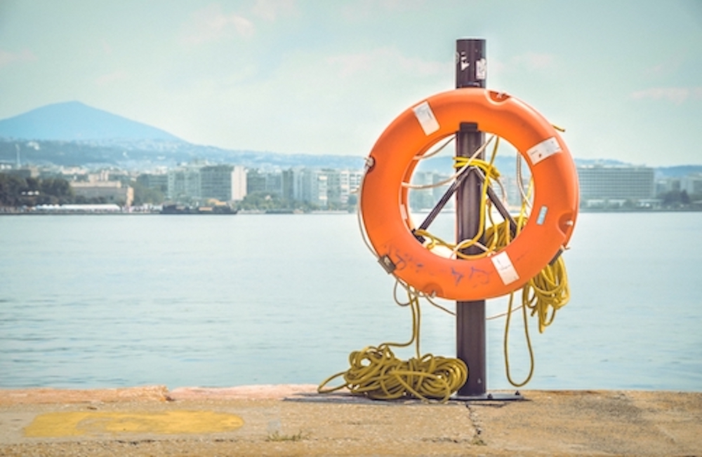 View life ring with water and city line in the background