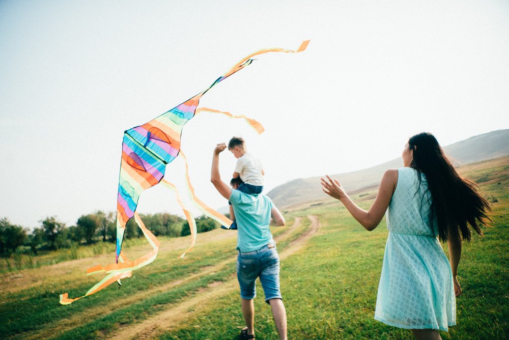 Family in field playing with Kite