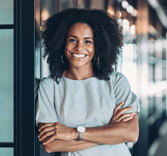 African American woman leaning against doorway with arms crossed