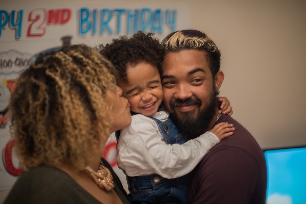 Parents hugging and kissing son