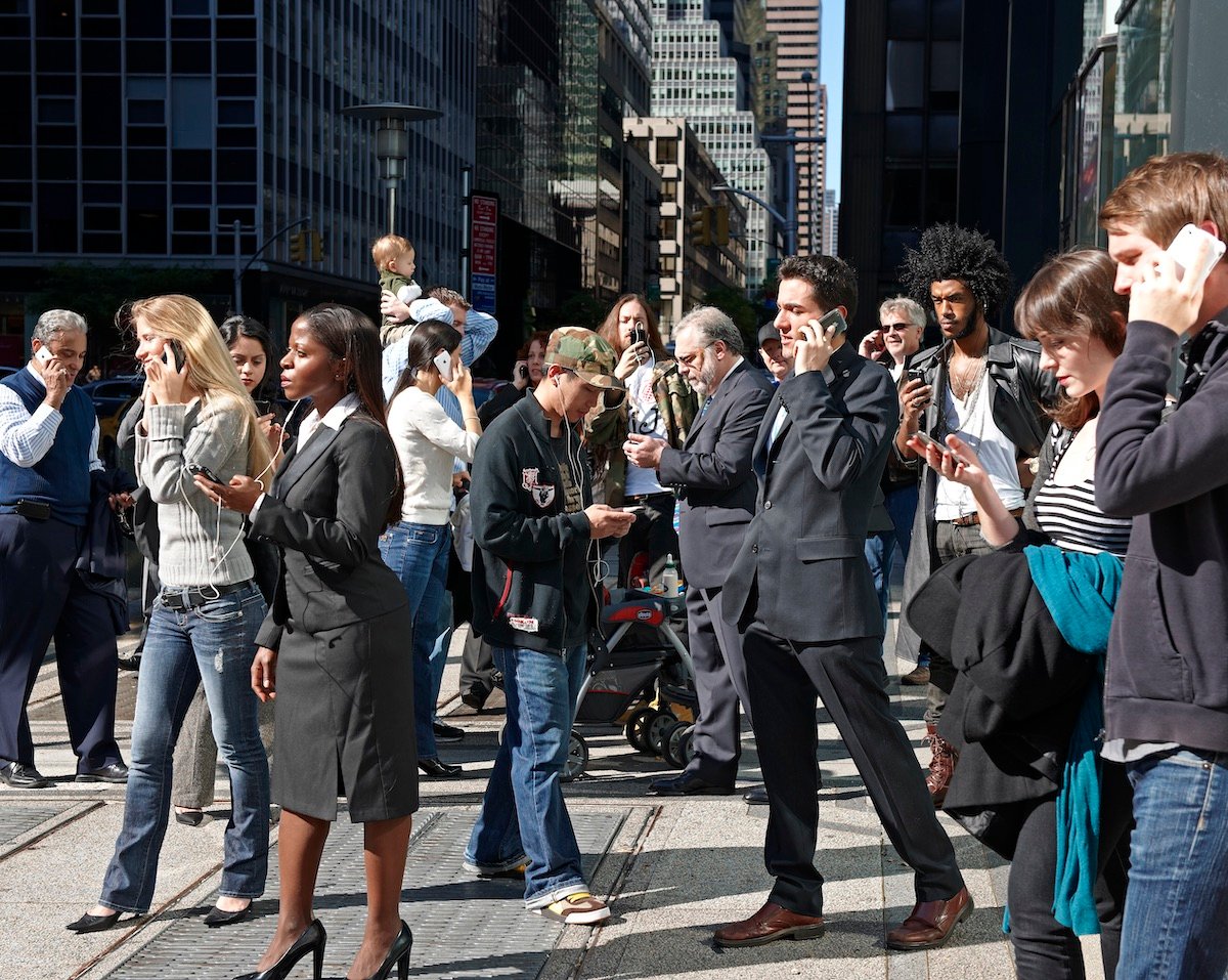 People using mobile phones in a busy city street