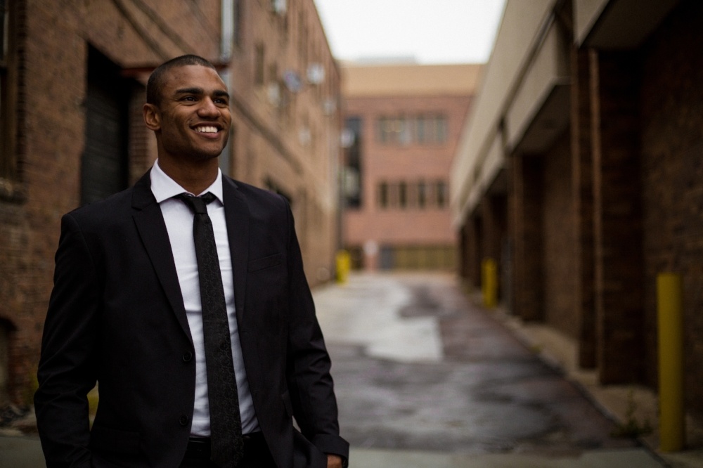 Well dressed man standing in an alleyway