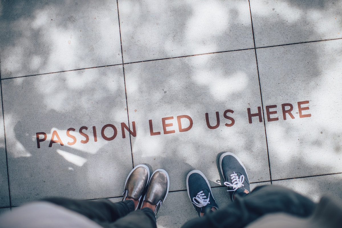 People standing near passion Led Us Here written on the floor