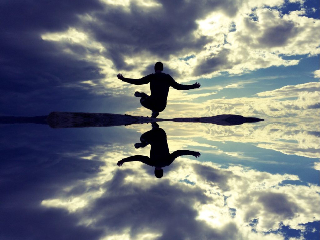 Man mediating by clear water