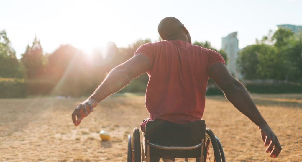 Man in wheelchair playing sport outside