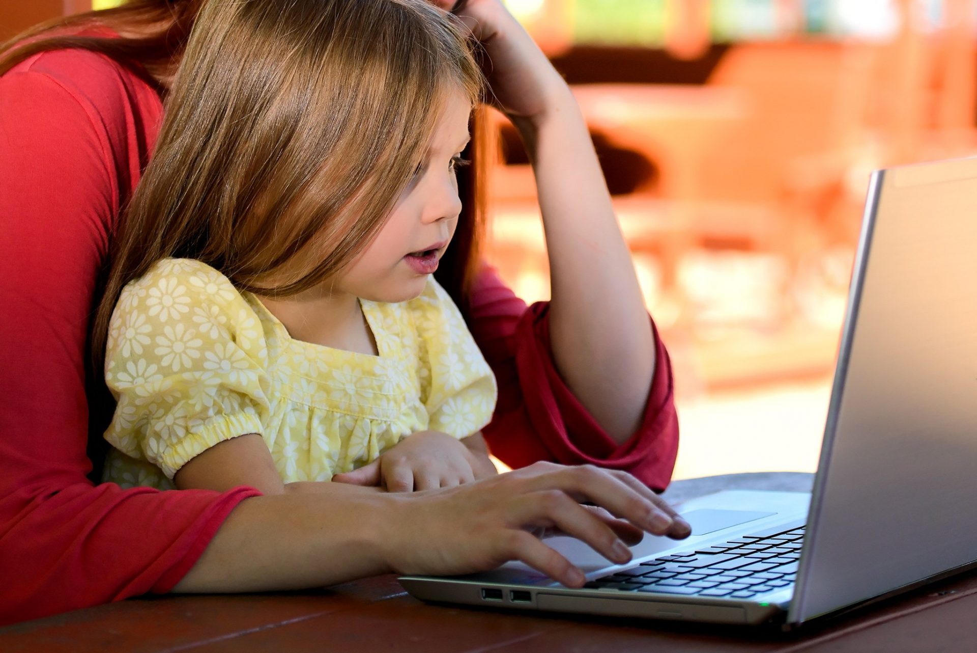 woman with her daughter in front of a laptop