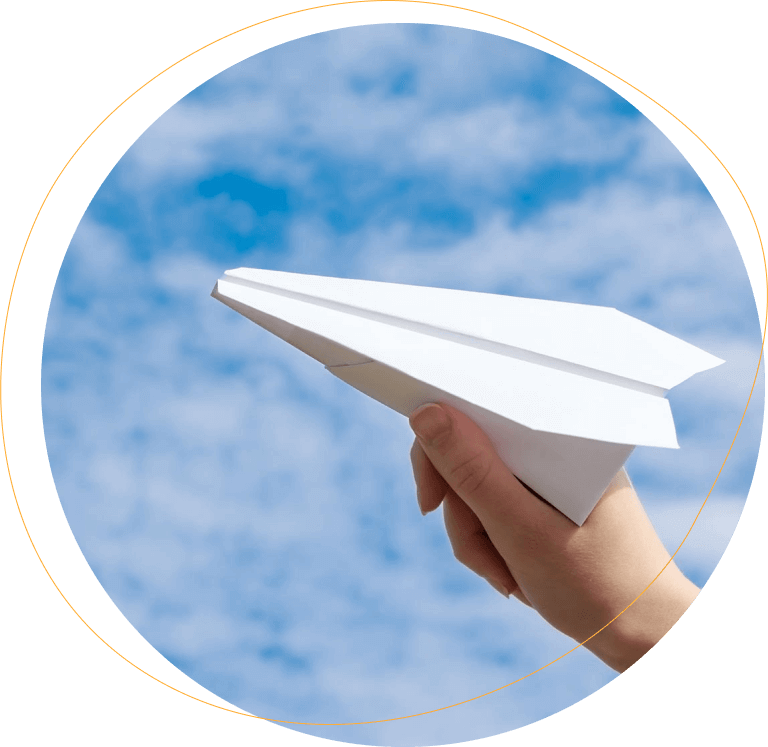 Hand holding paper plane towards the sky