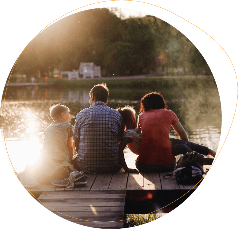 Family sitting on dock near a lake