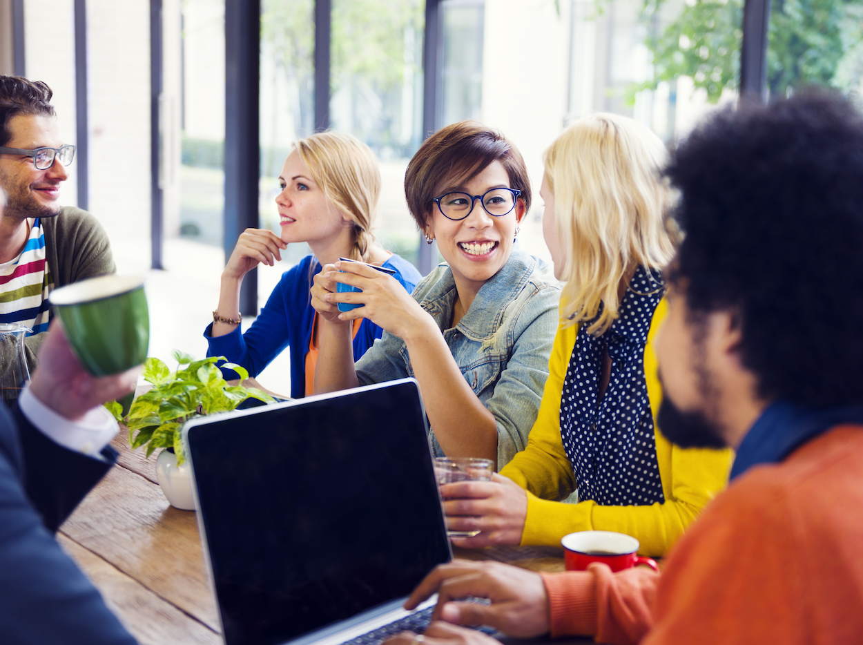 Group of employees chatting while drinking coffee