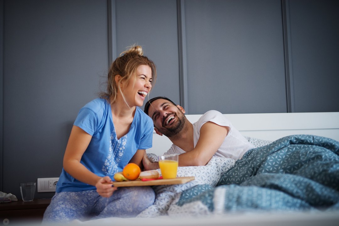 couple laughing by the bed