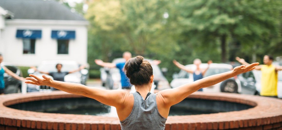 group of people in circle stretching arms out