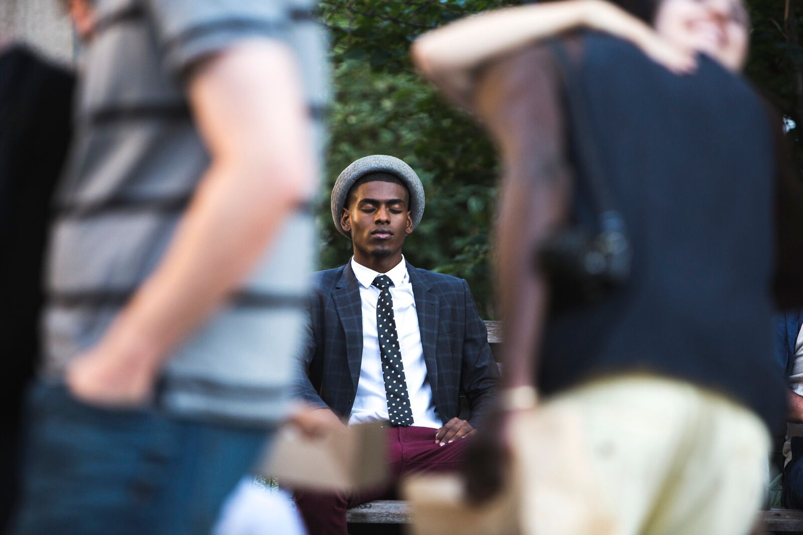 African American man sitting on a bench with eyes closed