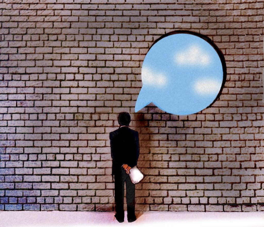 Man looking at brick wall thinking
