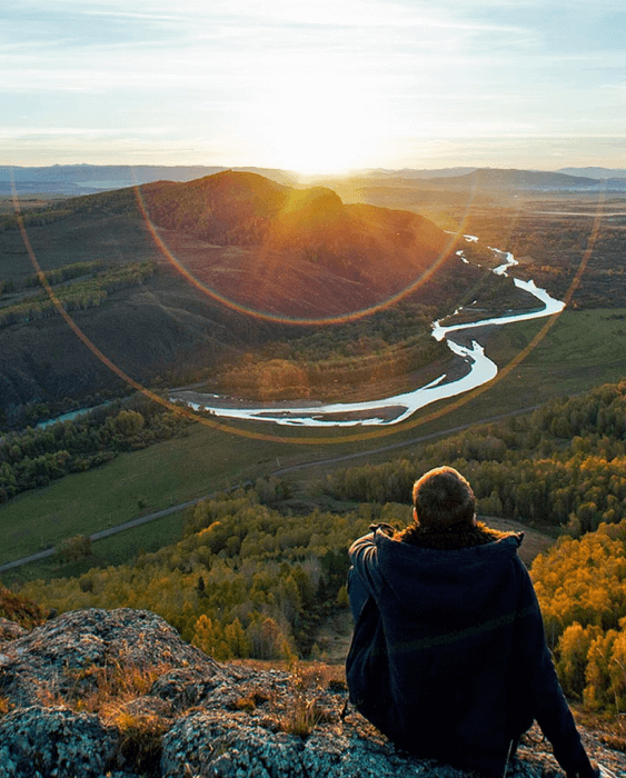 Person sitting on hill looking at nature