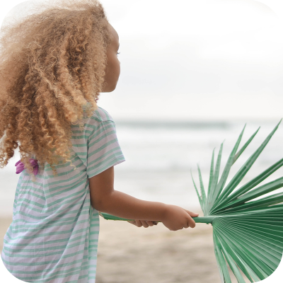 Young girl holding palm leaf