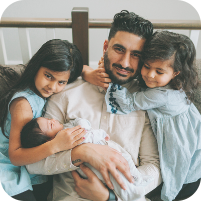 Father surrounded by his children sitting on couch
