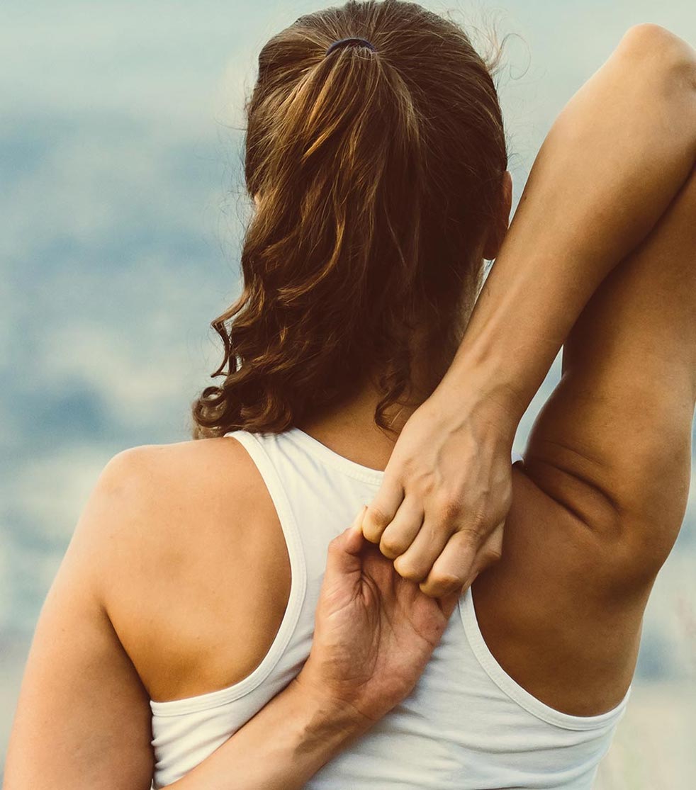 Back view of woman stretching her arms