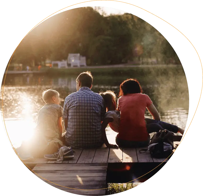 Family sitting on dock near a lake