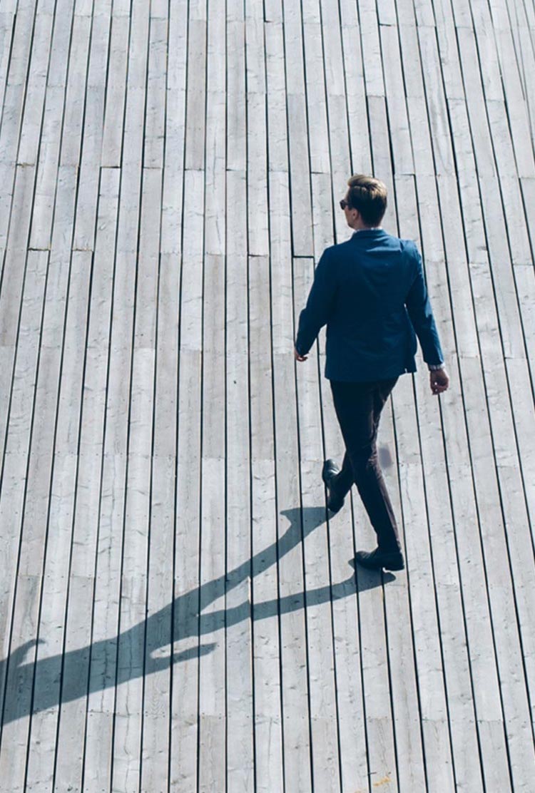 Man in suit walking on boardwalk