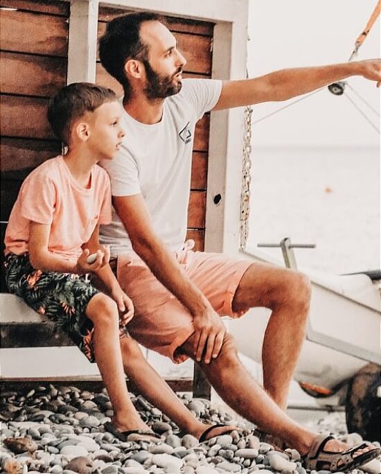 Father sitting and pointing with son