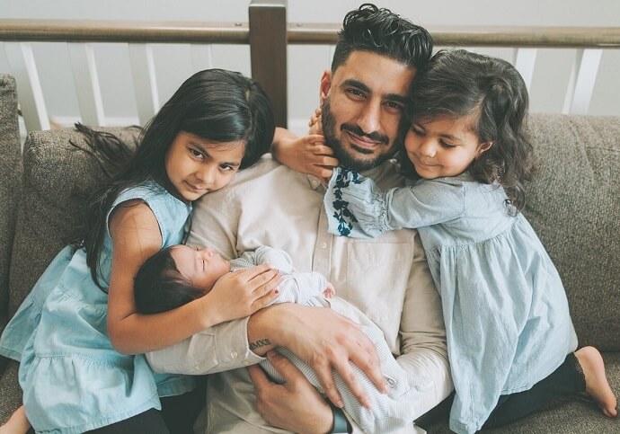 Father surrounded by his children sitting on couch