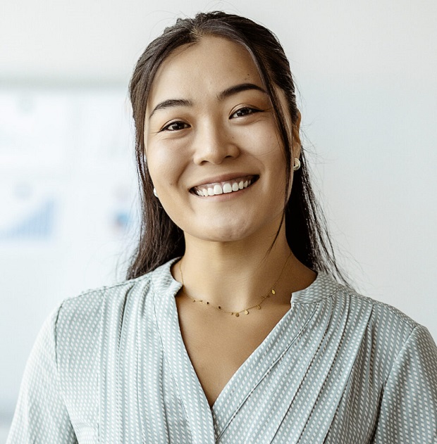 Confident young Asian businesswoman smiling in boardroom