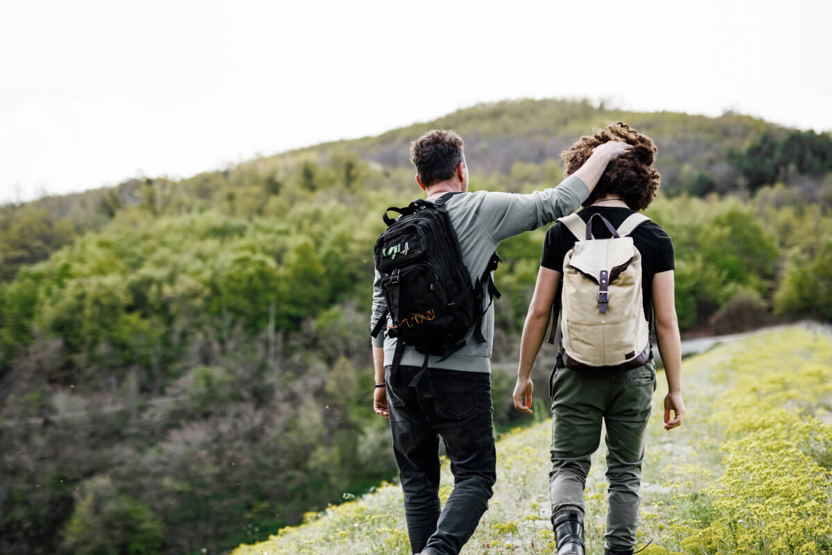 Father and son hiking having fun, father rubbing son's head