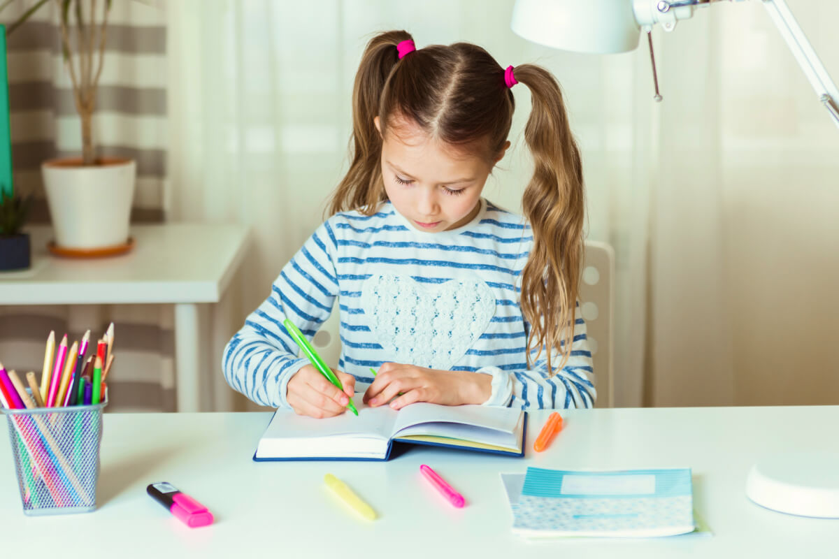 girl practicing executive functioning by writing in notebook daily planner