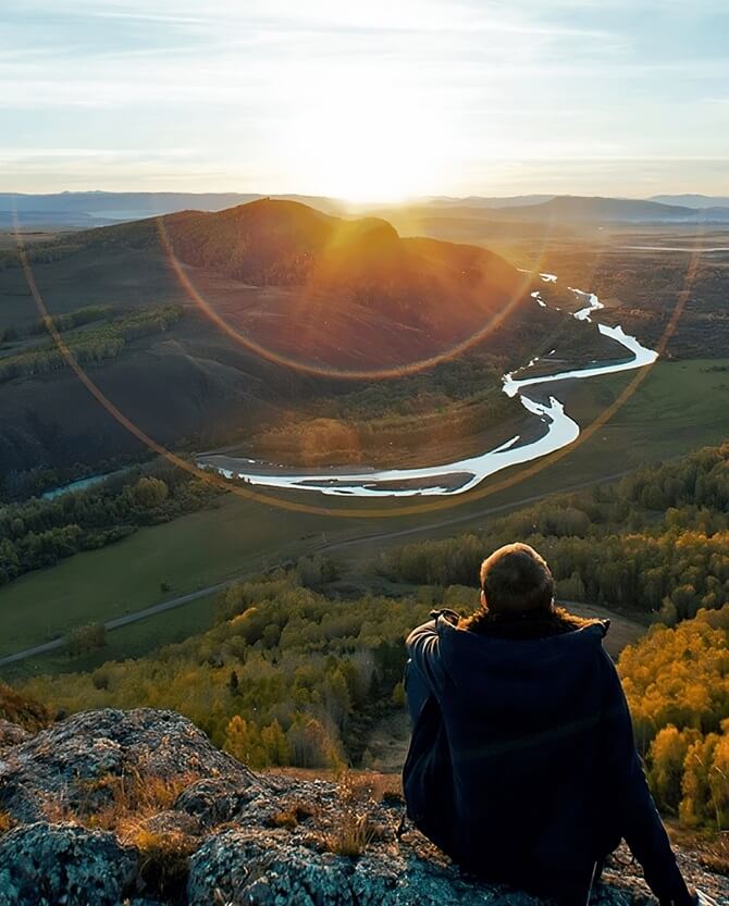 Person sitting on hill looking at nature