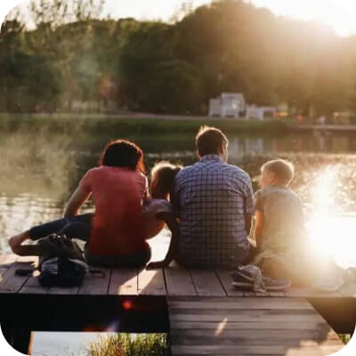 Family sitting on dock near a lake