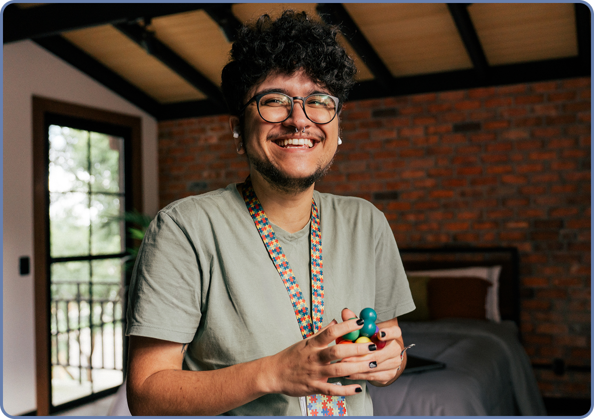 A happy person wearing glasses and holding sensory spheres.